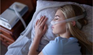 A woman using CPAP machine to address sleep apnea